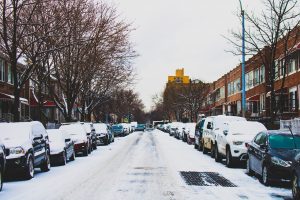 zaśnieżona ulica pełna aut